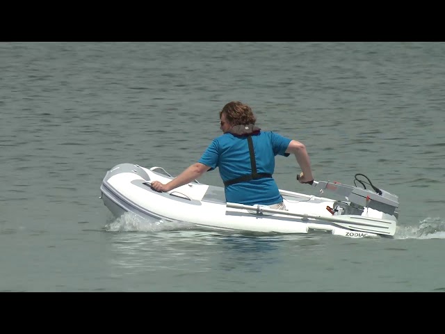 A compact Zodiac-style inflatable tender on the water.